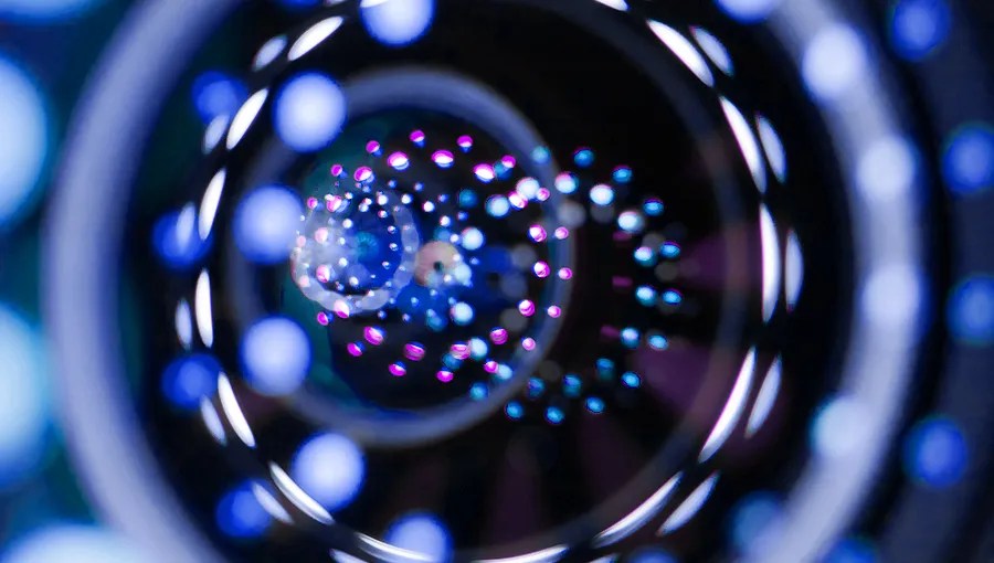 Abstract spiral pattern with blue, purple, and white glowing dots creating a tunnel-like illusion with striking precision to represent claims accuracy.