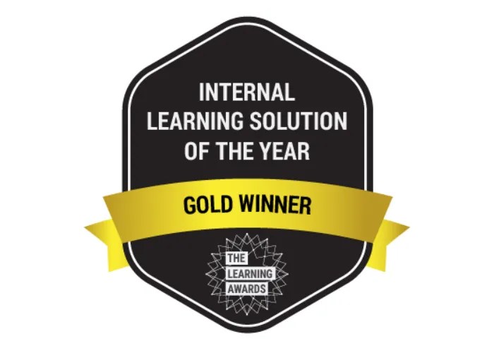 Black badge with a gold ribbon recognizes Awards: Internal Learning Solution of the Year Gold Winner, The Learning Awards.